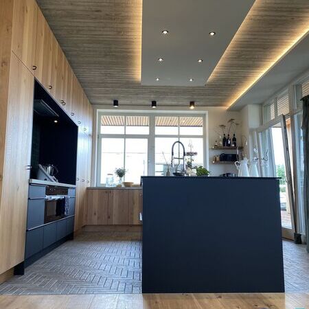 Küche aus Eiche, beleuchteter Decke und Kochinsel