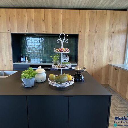 Moderne Küche aus Eiche mit Kochinsel und Kräutern und Früchten