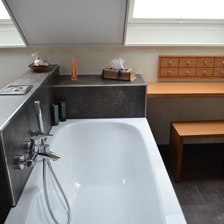 Fertig renoviertes Badezimmer mit halb freistehender Badewanne und Schminktisch