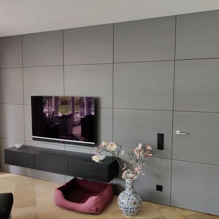 TV-Wand mit hängender Kommode, Steckdosen und verkleideter Eingangstür